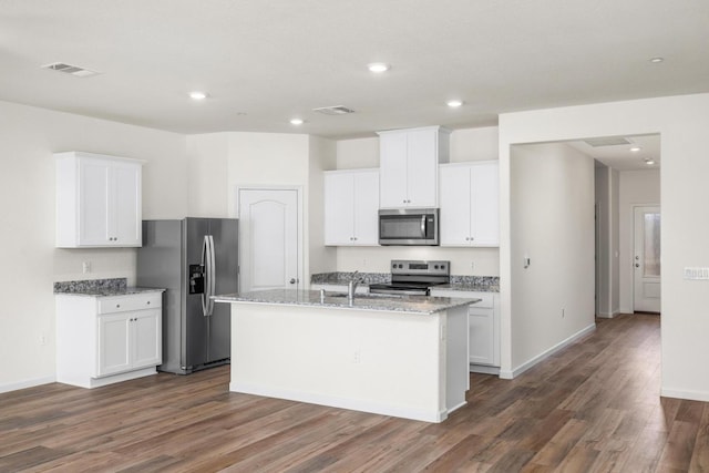 kitchen with visible vents, a kitchen island with sink, dark wood-style flooring, appliances with stainless steel finishes, and white cabinetry