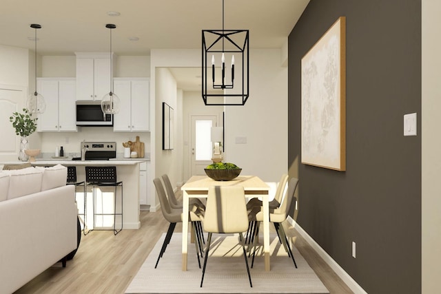 dining area featuring baseboards and light wood finished floors