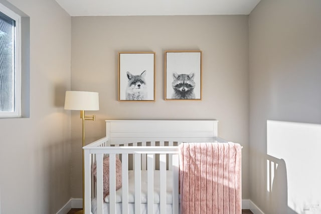 bedroom with a nursery area and baseboards