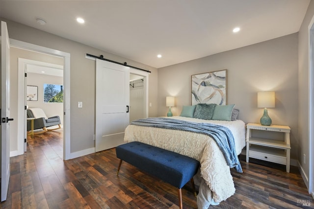 bedroom with dark wood-style floors, a barn door, baseboards, and recessed lighting