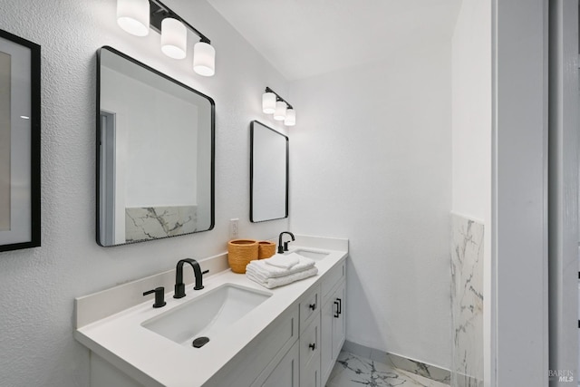 full bathroom featuring double vanity, marble finish floor, and a sink