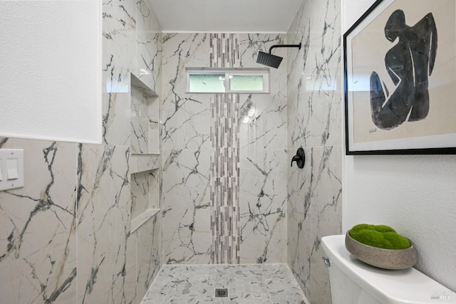 bathroom featuring toilet and a marble finish shower