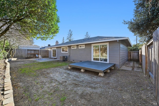 rear view of house featuring central air condition unit, a fenced backyard, a wooden deck, and a patio