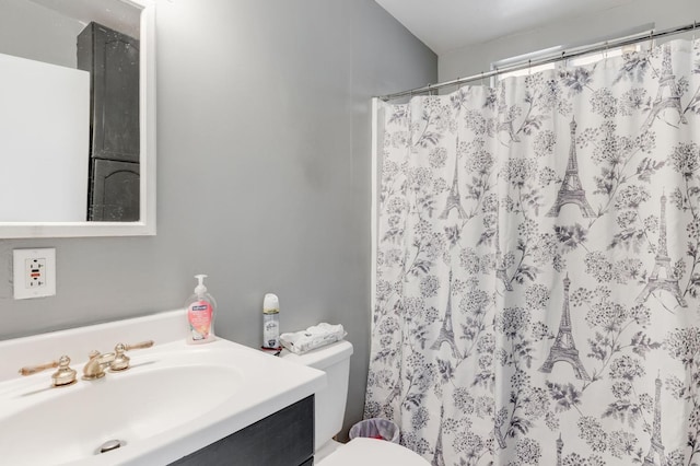 bathroom with curtained shower, vanity, and toilet