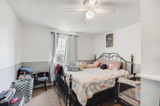 bedroom with ceiling fan, a textured ceiling, and carpet flooring