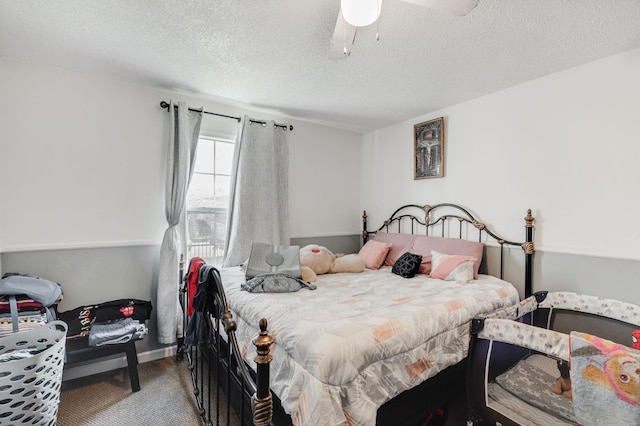 carpeted bedroom featuring ceiling fan and a textured ceiling