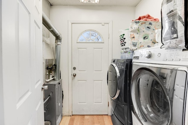 laundry room with light wood-type flooring, laundry area, and washer and clothes dryer