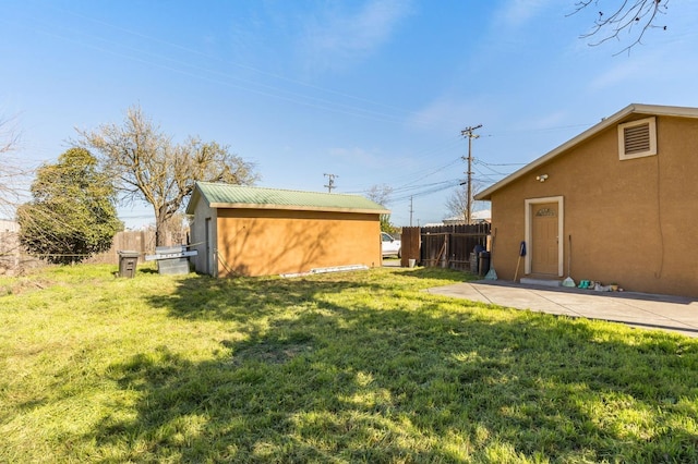 view of yard featuring a patio area, fence, and an outdoor structure