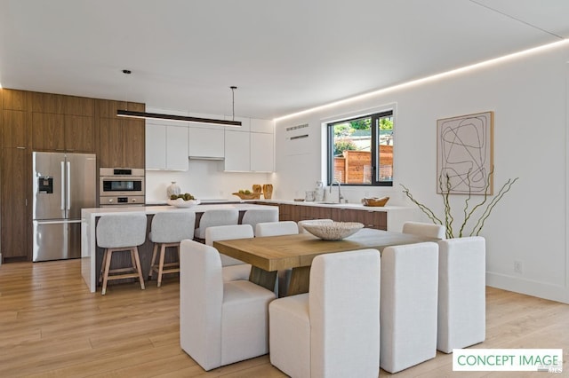 dining area with baseboards and light wood-style floors