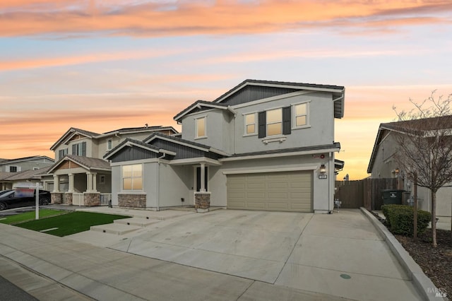 view of front of property with concrete driveway, fence, an attached garage, and stucco siding