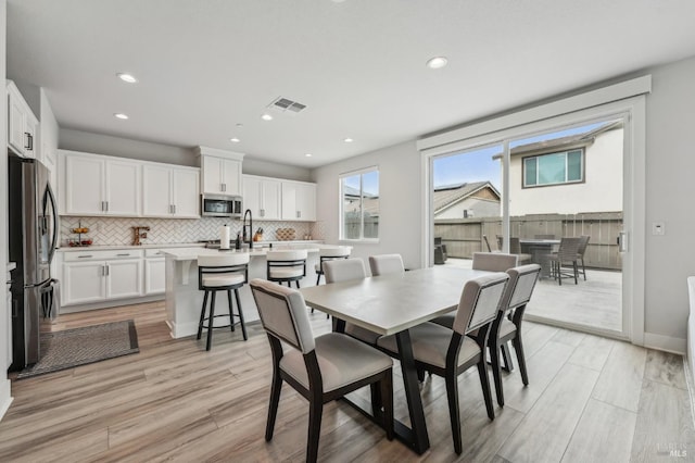 dining area featuring light wood-style flooring, visible vents, baseboards, and recessed lighting