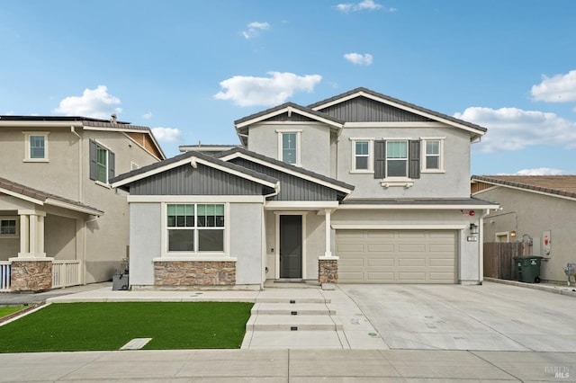 craftsman house with a garage, concrete driveway, fence, and stone siding