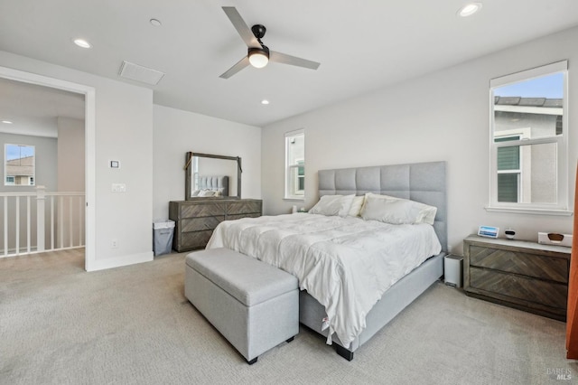 bedroom with light carpet, multiple windows, and recessed lighting