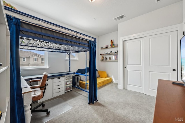 bedroom with a closet, visible vents, and carpet flooring