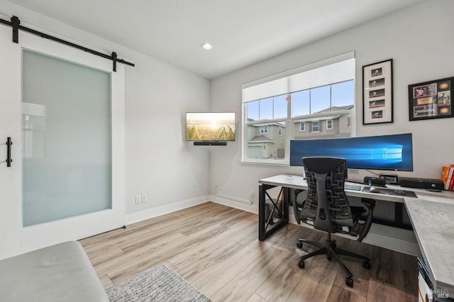 office space featuring recessed lighting, wood finished floors, baseboards, and a barn door