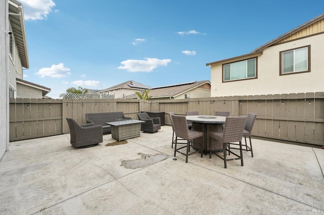 view of patio / terrace with outdoor dining area, an outdoor living space with a fire pit, and a fenced backyard