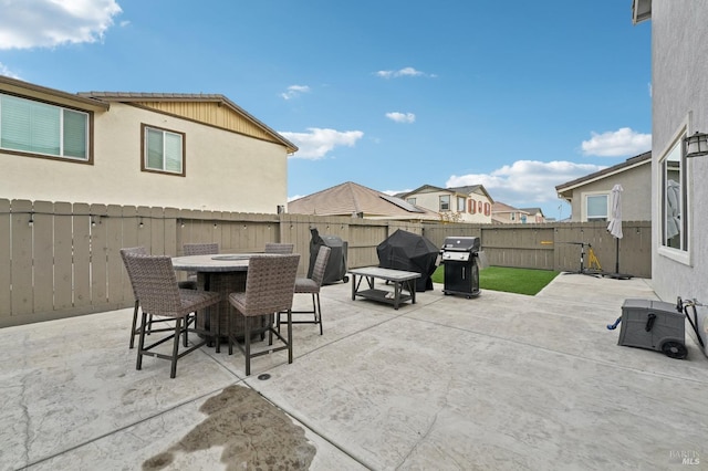 view of patio with a fenced backyard, grilling area, and outdoor dining space