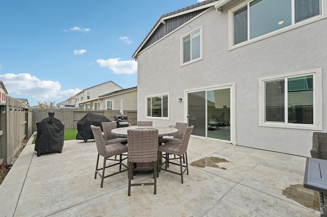 view of patio featuring outdoor dining area, a fenced backyard, and a grill