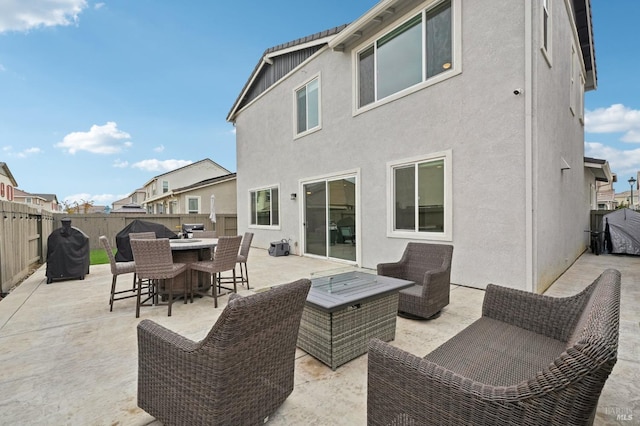 view of patio / terrace with an outdoor living space with a fire pit, a fenced backyard, and outdoor dining space