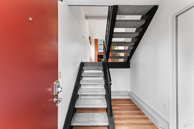 stairway featuring baseboards and wood finished floors