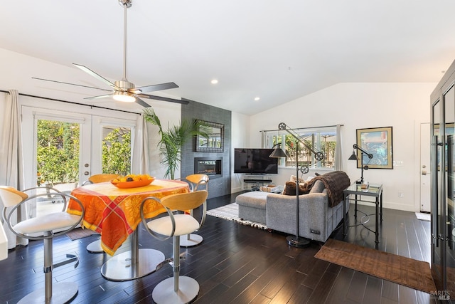 living area with dark wood finished floors, lofted ceiling, french doors, a fireplace, and recessed lighting