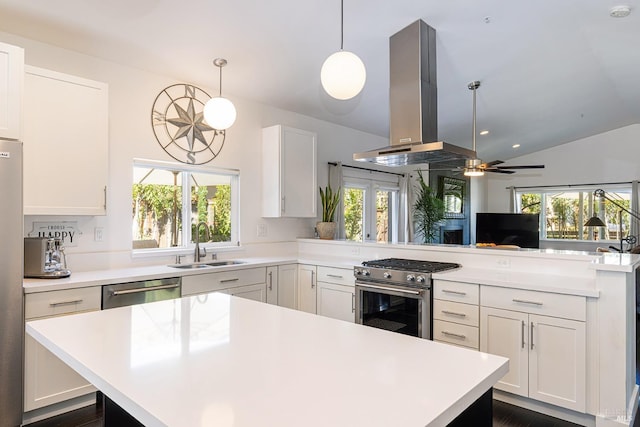 kitchen with stainless steel appliances, light countertops, a sink, a peninsula, and exhaust hood