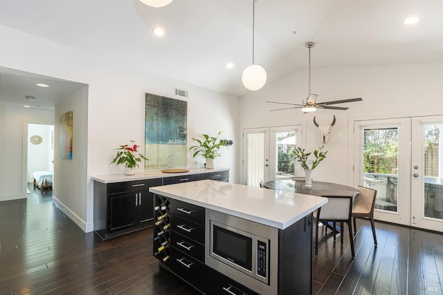 kitchen featuring dark cabinets, french doors, stainless steel microwave, and visible vents