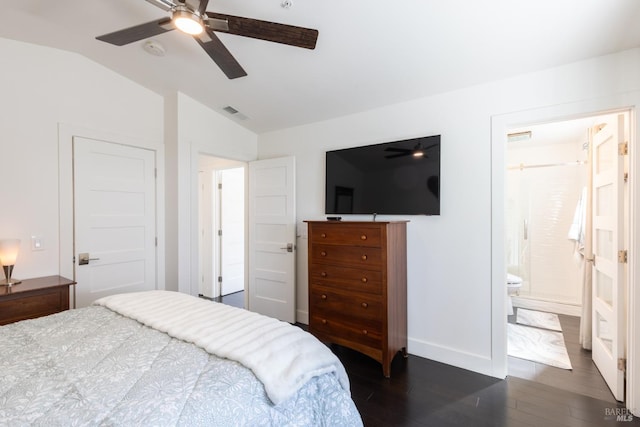 bedroom with lofted ceiling, connected bathroom, a ceiling fan, baseboards, and dark wood finished floors