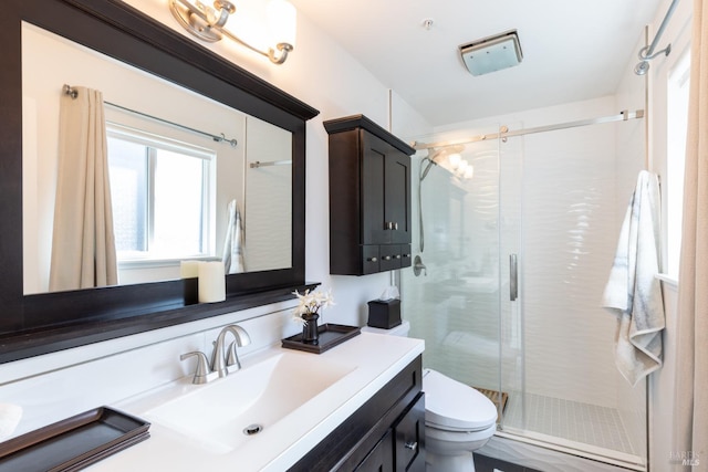 full bathroom featuring a stall shower, vanity, and toilet