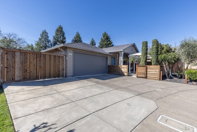 view of front of property with a garage, concrete driveway, and fence