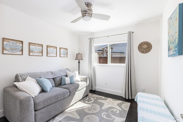 living room with dark wood-style floors, ceiling fan, and baseboards