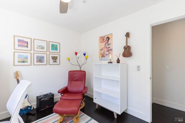 sitting room with dark wood-style floors, baseboards, and a ceiling fan