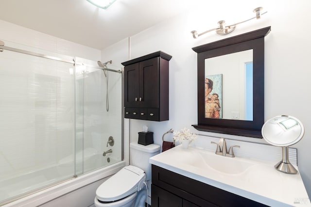 bathroom with toilet, combined bath / shower with glass door, and vanity