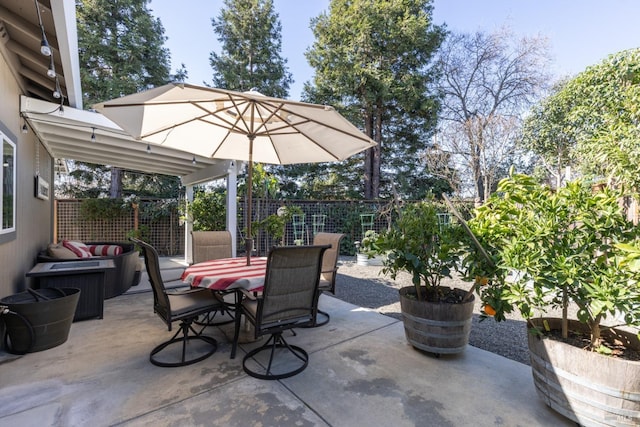 view of patio featuring outdoor dining space and fence