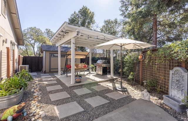 view of patio / terrace with a fenced backyard, area for grilling, and an outdoor structure