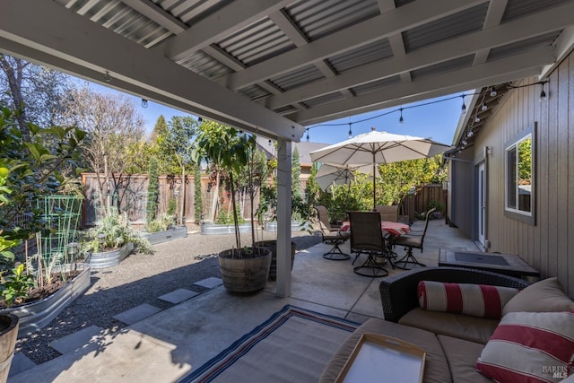 view of patio with a garden, a fenced backyard, and outdoor dining space