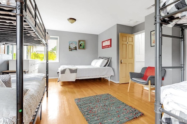 bedroom featuring wood finished floors, visible vents, and baseboards