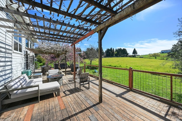 wooden deck featuring a fire pit, a lawn, a rural view, and a pergola