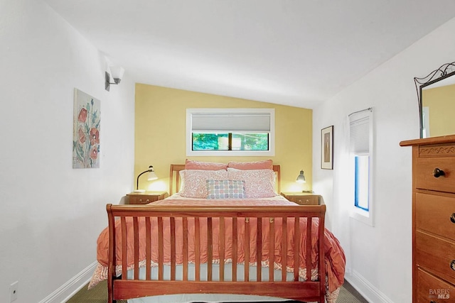 bedroom with lofted ceiling and baseboards