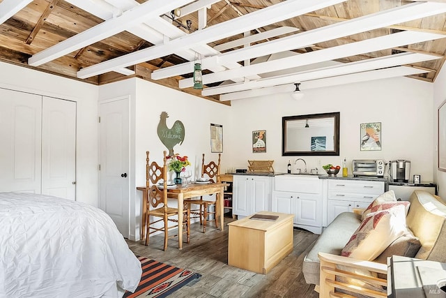 bedroom featuring a sink, wood ceiling, beam ceiling, and wood finished floors