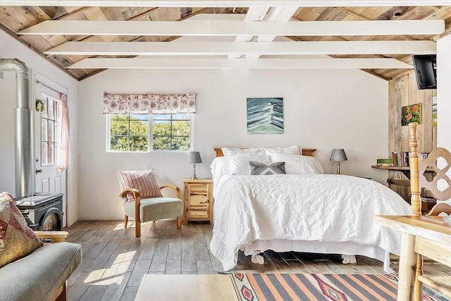 bedroom featuring a wood stove, vaulted ceiling with beams, wooden ceiling, and light wood-style floors