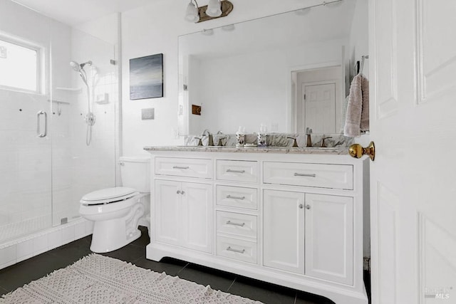 full bathroom featuring toilet, a sink, tile patterned floors, double vanity, and a stall shower