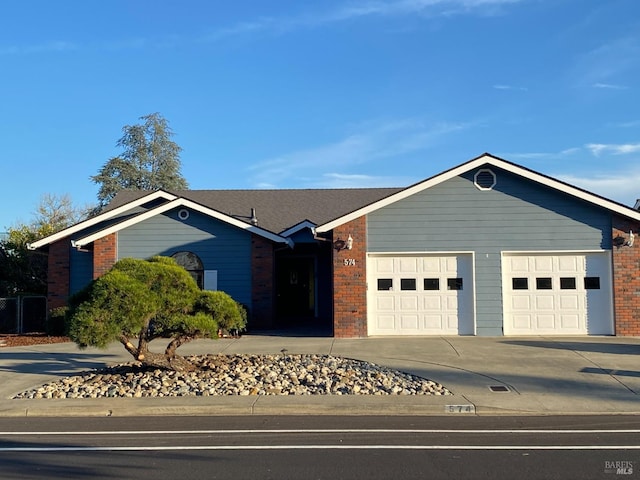 ranch-style home with a garage, concrete driveway, and brick siding