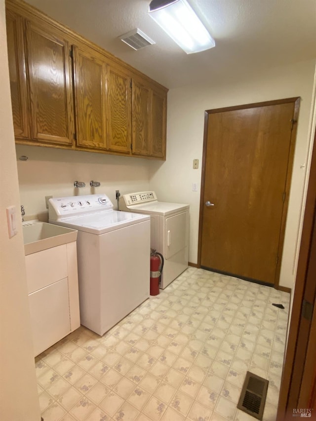 laundry area with light floors, cabinet space, visible vents, and washer and dryer