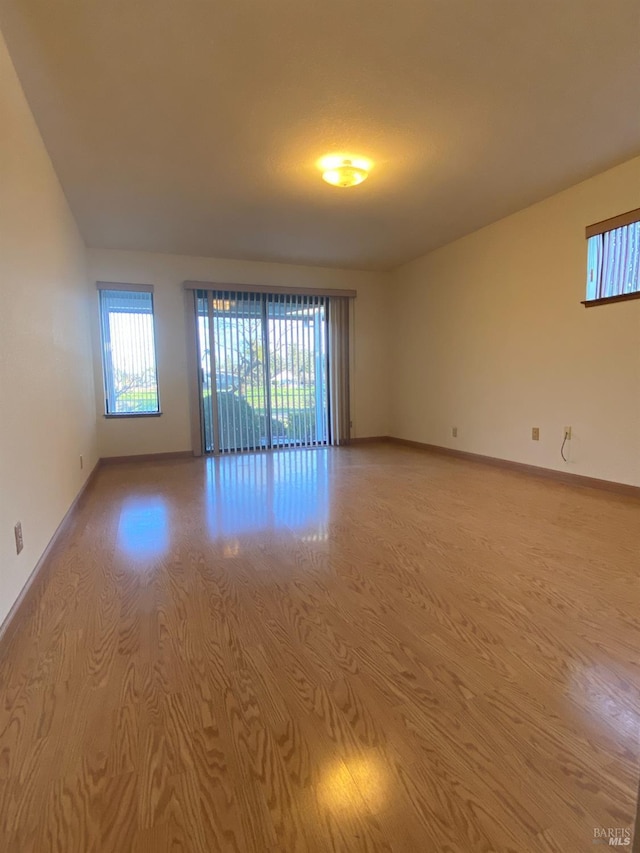 spare room with light wood finished floors and baseboards