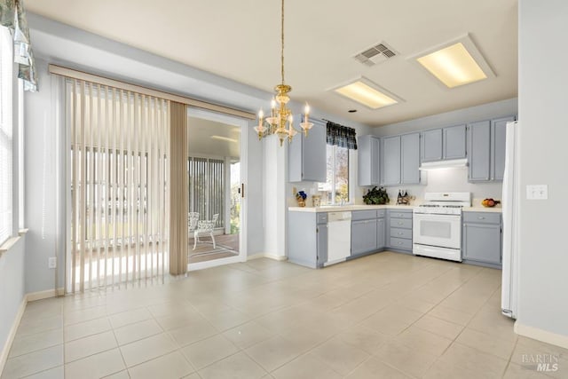 kitchen featuring white appliances, visible vents, gray cabinets, light countertops, and under cabinet range hood