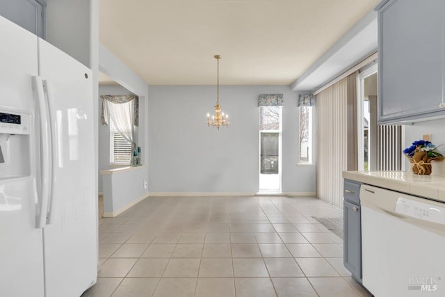 kitchen with tile counters, white appliances, plenty of natural light, and light tile patterned floors