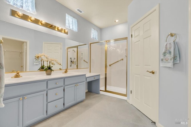 full bath featuring double vanity, a shower stall, visible vents, and a sink