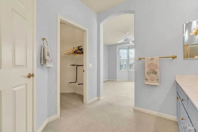 bathroom featuring ceiling fan, vanity, and baseboards