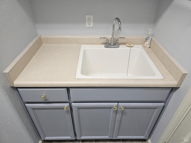 bathroom featuring a textured wall and a sink